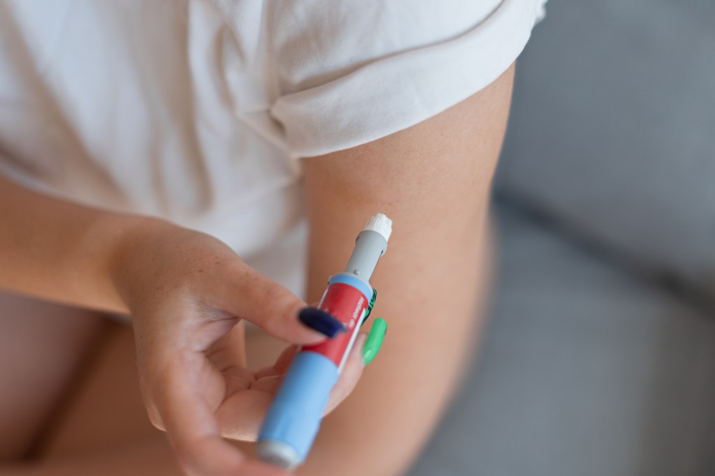 Girl giving a dose of antidiabetic medicine with injection pen at home for weight loss